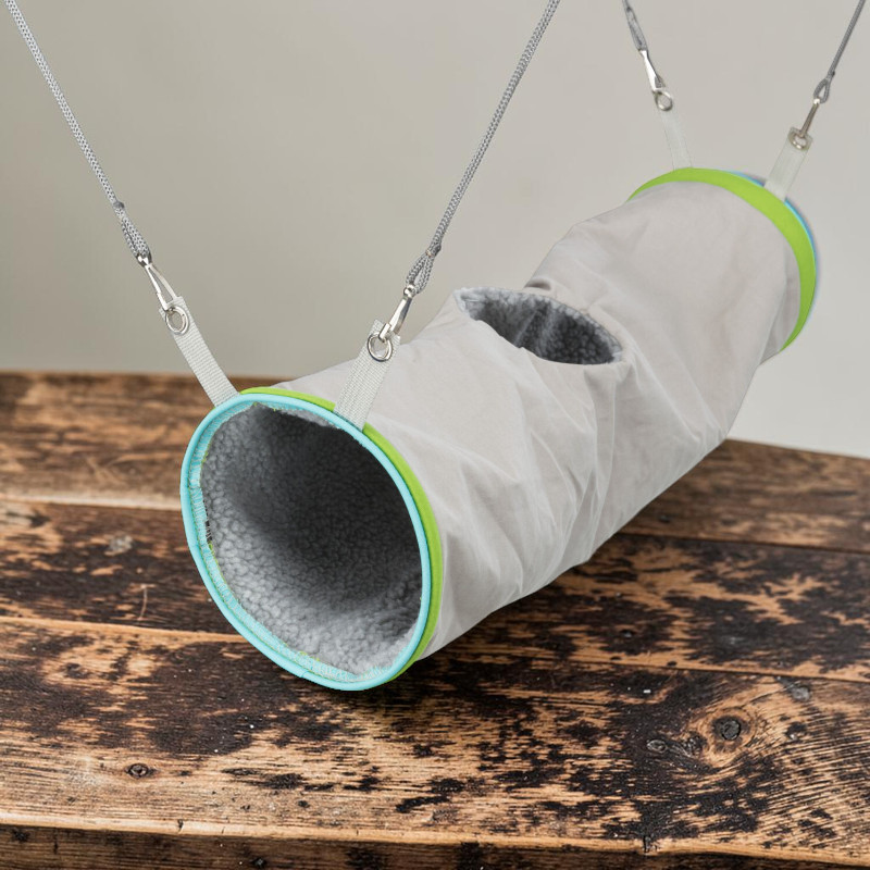 Grauer Stoff-Kuscheltunnel, innen mit weichem, flauschigem grauem Lammfell-Imitat gepolstert. Öffnungen an beiden Enden mit türkisen und lindgrünen Rändern sowie mittige Öffnung oben. Mit Riemen und Karabinern zum Aufhängen.