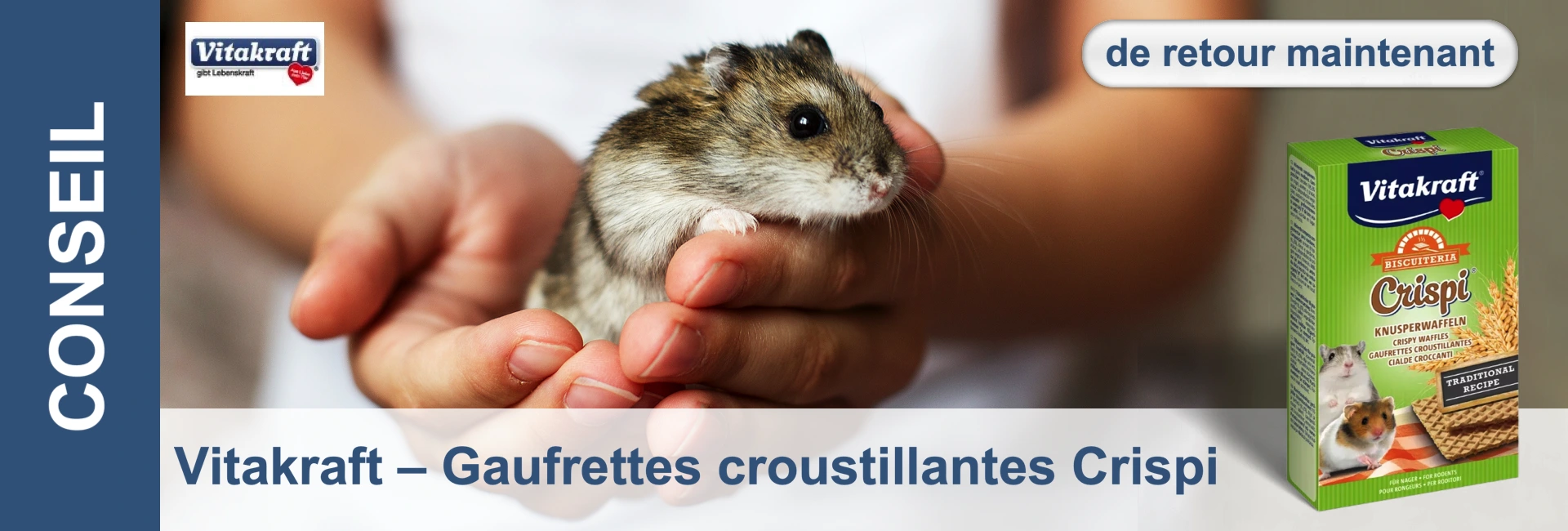 Un hamster est assis sur les mains d'une personne, à côté d'un paquet de gaufrettes croustillantes « Vitakraft Crispi ».