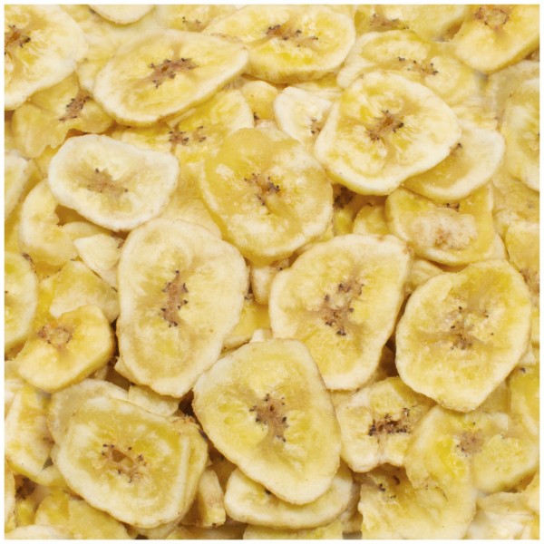 Une multitude de rondelles de banane séchées, d’un jaune doré, remplit l’image. Chaque rondelle, irrégulière, montre au centre des traces brunes plus foncées du cœur du fruit, leur donnant un aspect rustique.