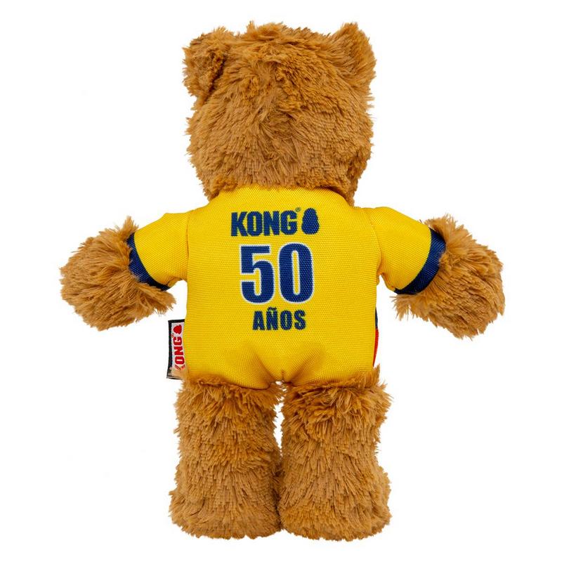 Un morbido orsacchiotto marrone è di spalle all'osservatore. Indossa una maglietta giallo brillante con dettagli blu sulle maniche. Sulla schiena: in alto il logo Kong, sotto il numero 50 in grande e "AÑOS" in piccolo – 50° anniversario.