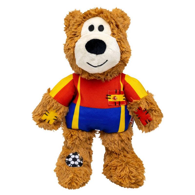 Orsacchiotto di peluche marrone con maglietta rosso-blu e bretelle gialle, visto di fronte. Sul petto una piccola bandiera spagnola. Toppe sulle zampe: croce gialla sin., croce rossa des. Piede sin.: palloni da calcio bianco-nero.