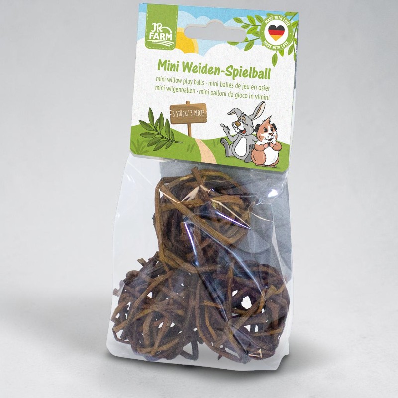 Eine transparente Verpackung mit drei natürlichen, geflochtenen Weidenbällen für Kleintiere. Die braunen Spielbälle sind von der Marke JR FARM, was auf dem hellgrünen Etikett oben zu sehen ist. Dort sind auch ein Hase und ein Meerschweinchen abgebildet.