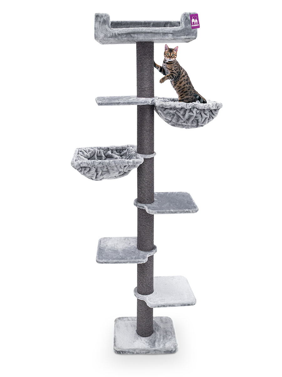 Alto tiragraffi grigio con diversi livelli e nicchie su sfondo bianco. Un gatto tigrato salta da un'amaca in alto. Offre superfici per arrampicarsi e riposarsi, con una piccola etichetta petrebels viola.