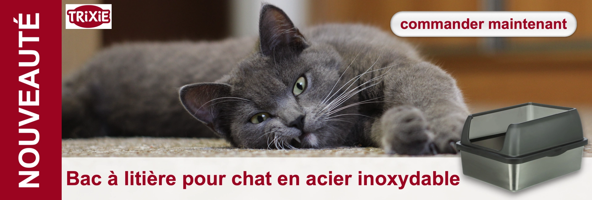 Un chat gris aux yeux verts est allongé, détendu, sur un tapis beige et regarde droit devant lui. À côté de lui se trouve une litière moderne en acier inoxydable avec un couvercle gris, qui présente le nouveau produit Trixie. Commandez dès maintenant !