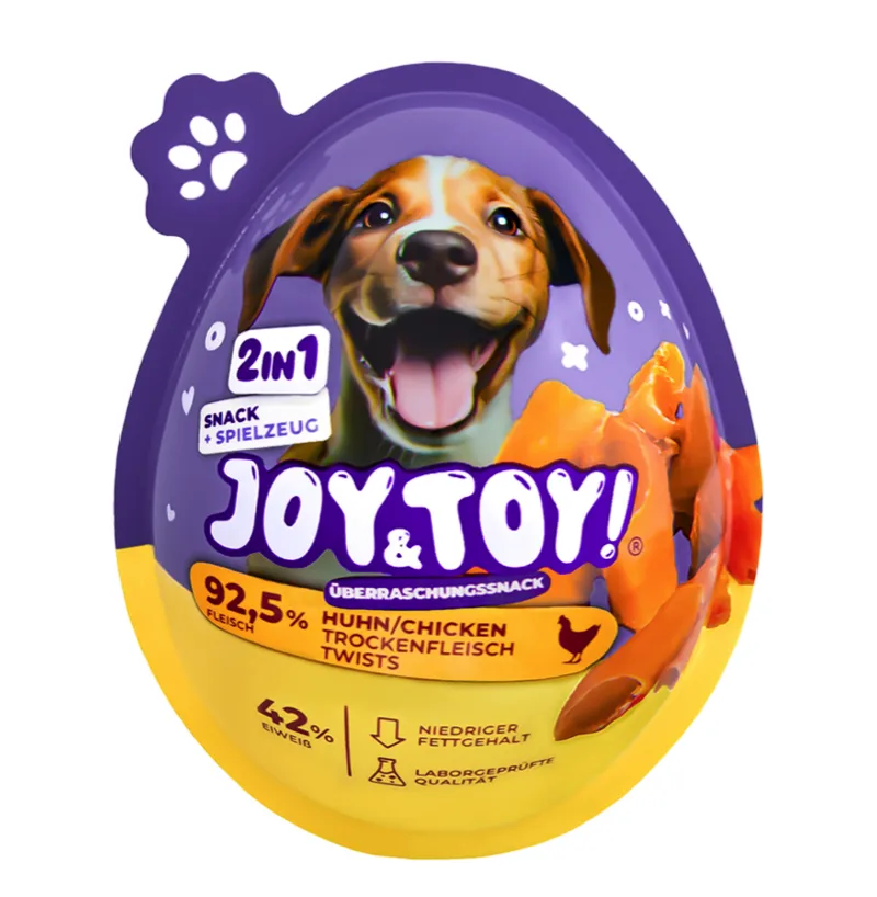 Lila-gelbe, eiförmige Verpackung von Joy & Toy Überraschungssnack für Hunde. Oben ein fröhlicher Hundekopf mit heraushängender Zunge. Wirbt mit "2in1 Snack + Spielzeug", 92,5% Fleisch, 42% Eiweiß, fettarm, laborgeprüft.