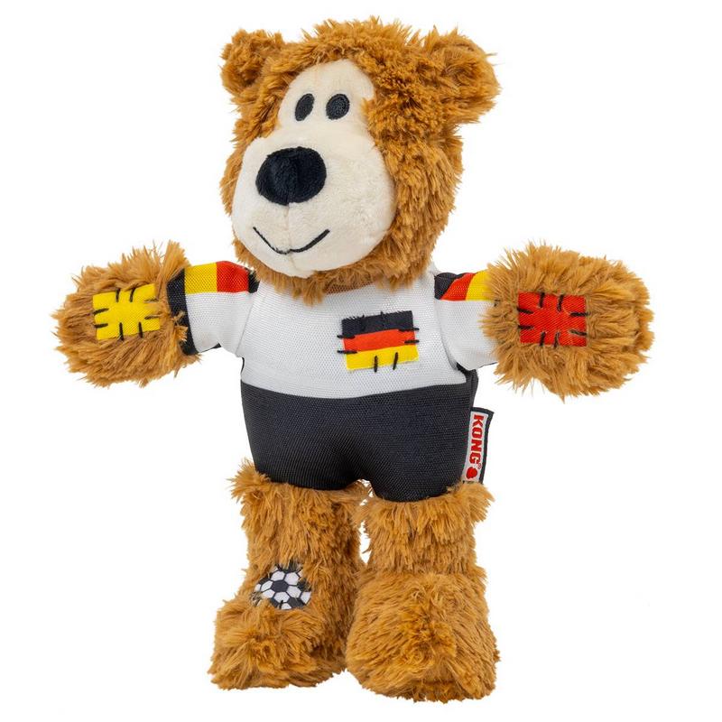 Orsacchiotto di peluche marrone con maglia da calcio bianca e pantaloncini neri. Maglia con colori della bandiera tedesca su maniche e petto. Toppe ricamate su zampe e piedi con palloni bianchi e neri. Sorriso simpatico, muso bianco.
