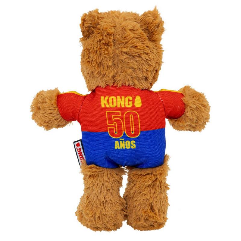 Un orsacchiotto marrone e soffice visto di schiena indossa una maglietta rossa e blu. Sulla parte rossa c'è scritto "Kong", sotto c'è in grande "50" e "AÑOS" in giallo. Orecchie corte e folte, braccia e gambe pelose su sfondo bianco.