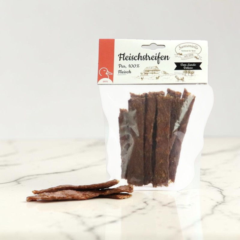 Getrocknete Pur-Fleischstreifen aus Ente für Hunde, abgepackt in einem transparenten Beutel und daneben liegen einige einzelne Streifen auf einer marmorierten Oberfläche. Die dunklen Fleischsnacks sind als Belohnung oder Kaubeschäftigung gedacht.