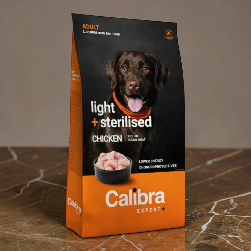Calibra Expert+ Hundefutter für ausgewachsene, kastrierte oder übergewichtige Hunde. Vorderseite: dunkelbrauner Labrador mit orangefarbenem Halstuch. Aufschrift „light + sterilised CHICKEN“ und Schale mit Hühnerwürfeln.