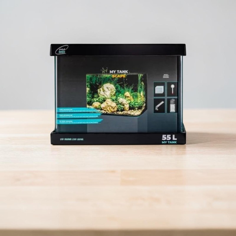 Schwarze Aquarium-Box auf heller Holzoberfläche. Vorderseite zeigt ein eingerichtetes Mini-Aquarium mit grünen Wasserpflanzen und braunen Steinen. Rechts Piktogramme von Zubehör wie Filter, Heizer und Lampe. Unten: "55 L MY TANK".