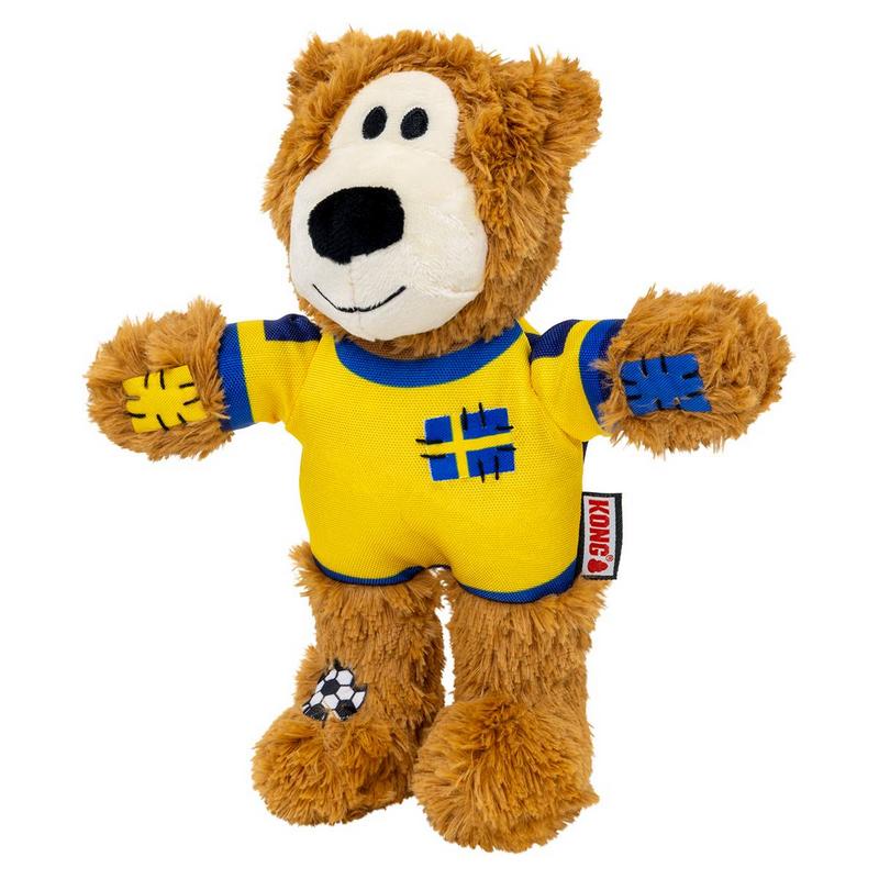 Orsacchiotto di peluche marrone con maglietta gialla bordi blu. Sul petto croce blu tipo bandiera svedese. Toppe blu sulle braccia, toppa a pallone da calcio sul piede sinistro. Muso chiaro, occhi e naso neri. Etichetta Kong sul fianco.