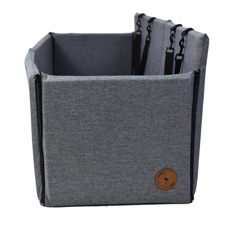 Lit pour chien rectangulaire et gris, à fixer aux appuie-tête. Doté de fermetures éclair latérales ainsi que de sangles noires et de mousquetons à l'arrière pour le maintenir en place. Petit logo rond et marron « Lauren Design » à l'avant.