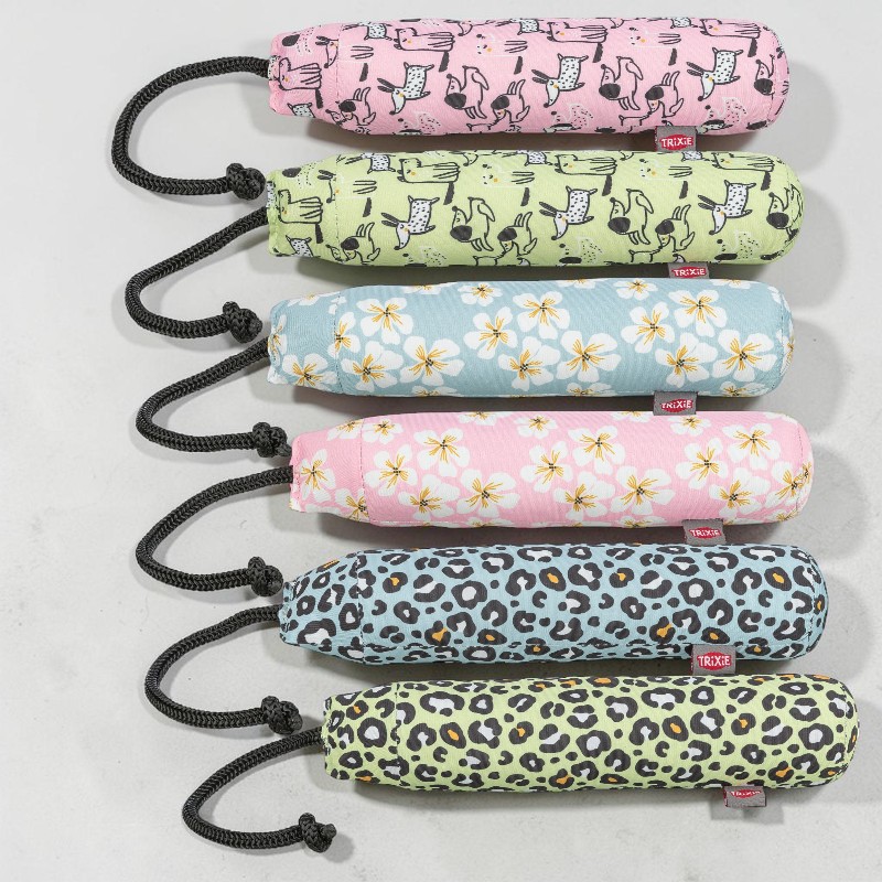 Sechs bunte Apportierspielzeuge für Hunde in Zylinderform, jeweils mit schwarzer Zugleine. Zwei zeigen Cartoon-Hunde (rosa/hellgrün), zwei weiße Blüten (hellblau/rosa) und zwei Leopardenmuster (hellblau/hellgrün). Auf hellgrau.
