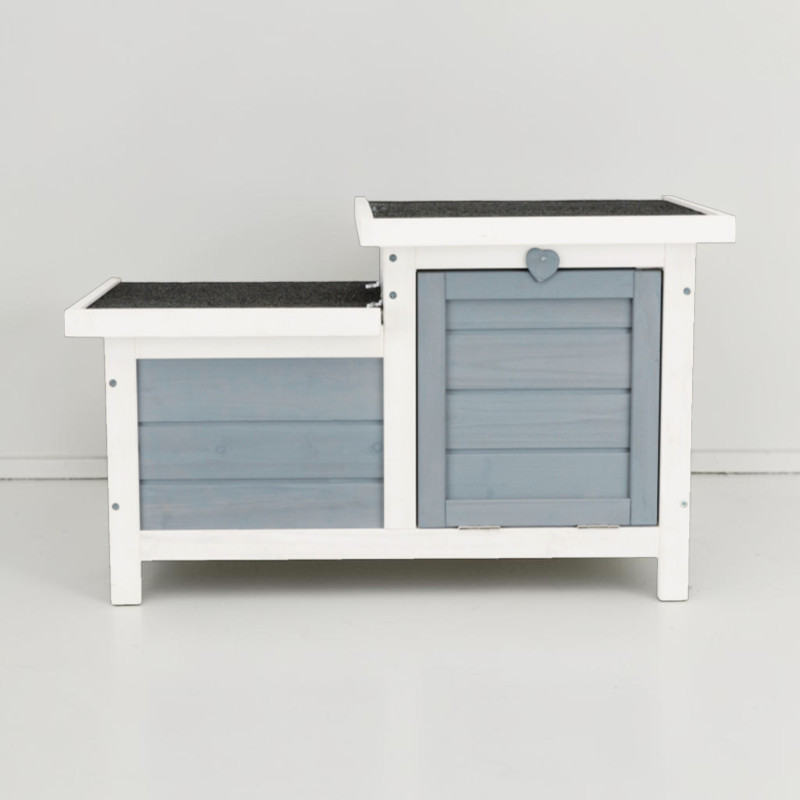 Zweigeteiltes Kleintierhaus aus weiss-grau lasiertem Kiefernholz. Zwei Dächer mit dunkler Dachpappe, graue horizontal gelattete Wände. Rechter Teil höher mit kleiner herzförmiger Verriegelung. Auf kurzen weissen Beinen.