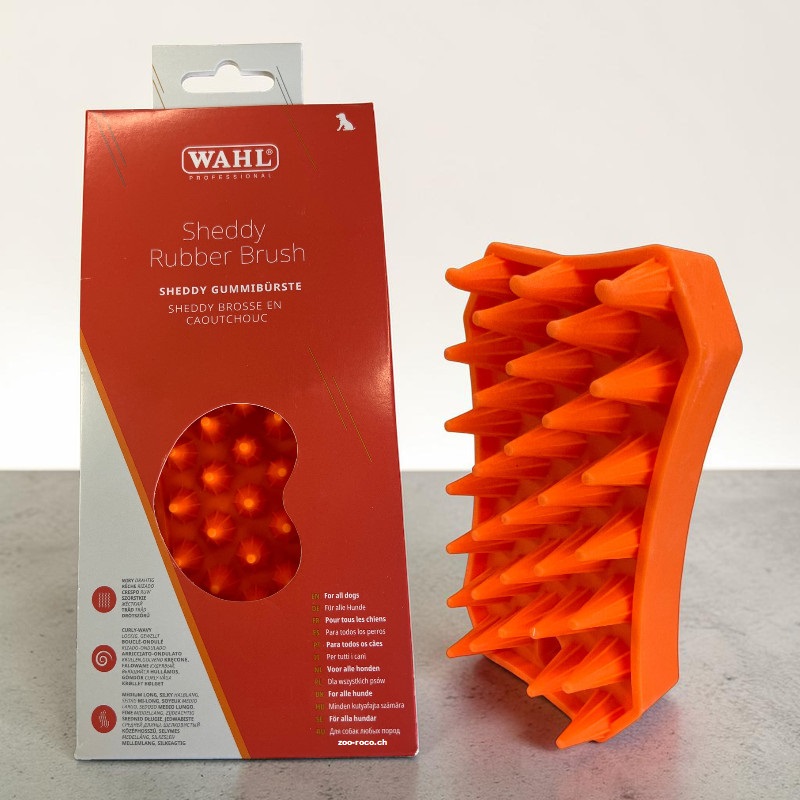 Leuchtend orange Sheddy Gummibürste von Wahl für Haustiere neben rot-oranger Verpackung. Weiche, konische Silikonzinken in Reihen zur Fellpflege, Entfernung von losem Fell und sanften Massage von Hunden und Katzen.