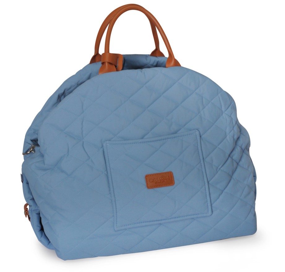 Borsa per pannolini trapuntata azzurra con due manici marroni in similpelle. Superficie morbida e imbottita con cuciture a rombi e tasca frontale applicata con piccola etichetta marrone del marchio. Immagine ritagliata su sfondo bianco.