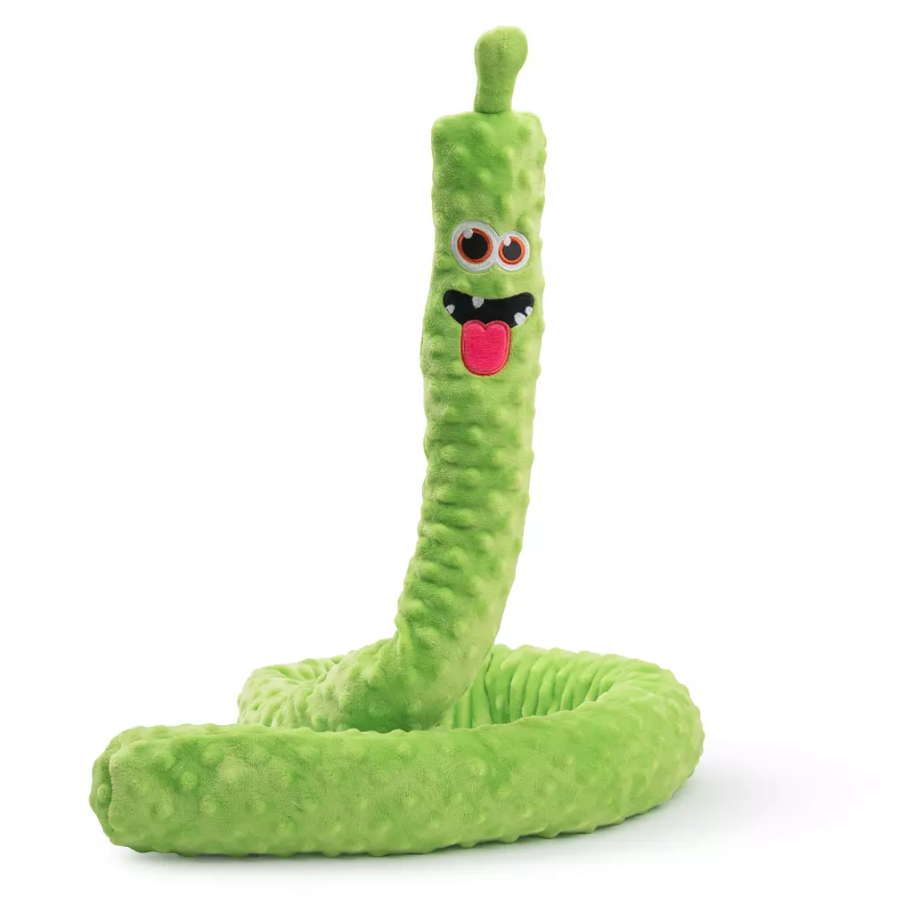 Un lungo peluche verde chiaro con superficie a protuberanze, attorcigliato a forma di serpente. In alto ha un volto da cartone animato con grandi occhi, denti bianchi e lingua rossa. Sta in piedi, con base a spirale.