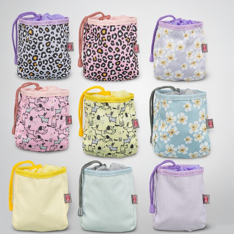 Neun farbenfrohe Leckerlie-Beutel für Haustiere im 3x3-Raster. Mit Kordelzug, in Pastelltönen. Muster: Leopardenprint, zarte Blumen, stilisierte Hunde und unifarbene Texturen. Jeder Beutel mit TRIXIE-Etikett.