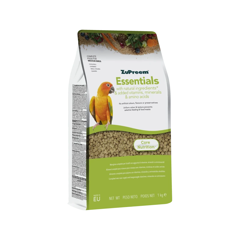 Packaging bianco-verde del mangime per uccelli ZuPreem Essentials. In primo piano un pappagallo sole arancione brillante, accanto a carote, bacche e cereali. Finestra con pellet verdi. Ingredienti naturali, vitamine e aminoacidi.