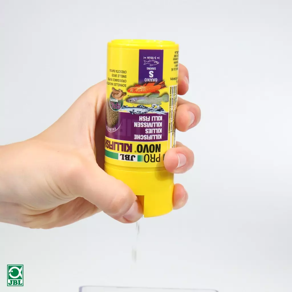 Dosage manuel de la nourriture pour poissons JBL PRONOVO KILLIFISH Grano S dans une boîte jaune. Illustration de poissons killis sur l'étiquette.