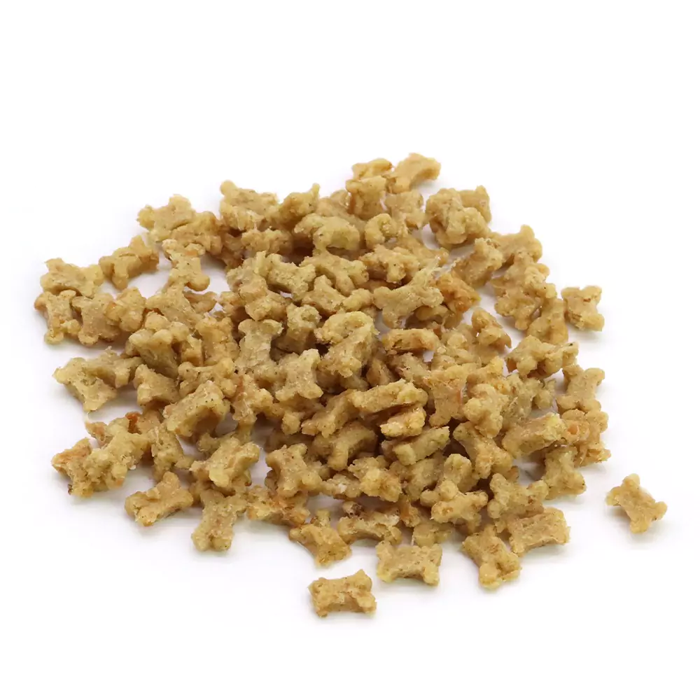 Un mucchio di pezzi di soia strutturati di colore marrone chiaro su sfondo bianco.