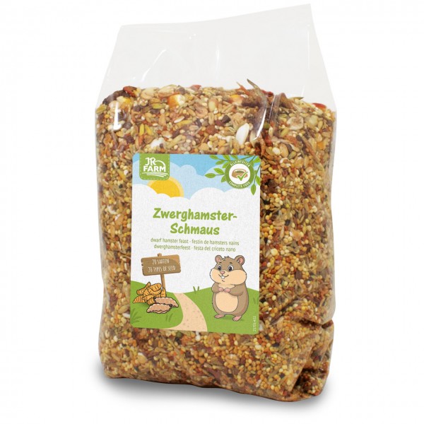 Transparente Plastiktüte mit Mischung aus Samen, Getreide und getrockneten Zutaten als Zwerghamsterfutter. Vorn auf dem Etikett: „JR Farm Zwerghamster-Schmaus“, cartoonartiger Hamster, Hinweis „20 Sorten“.