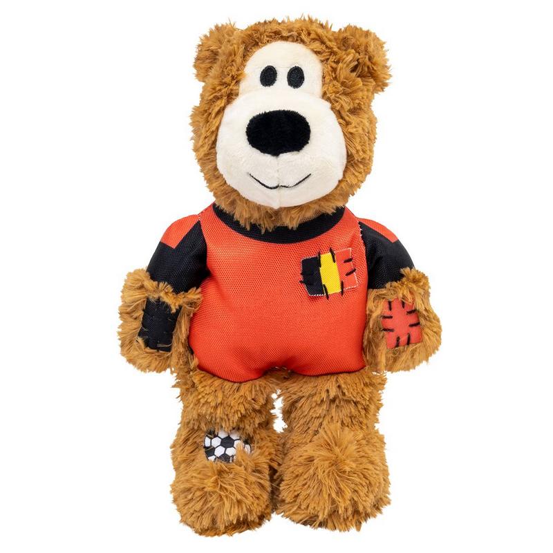 Orsacchiotto marrone con maglia da calcio arancione e nera e toppa nera, gialla e rossa. Bocca bianca, occhi e naso neri. Piccola toppa con pallone da calcio sulla zampa, toppa rossa sul braccio.
