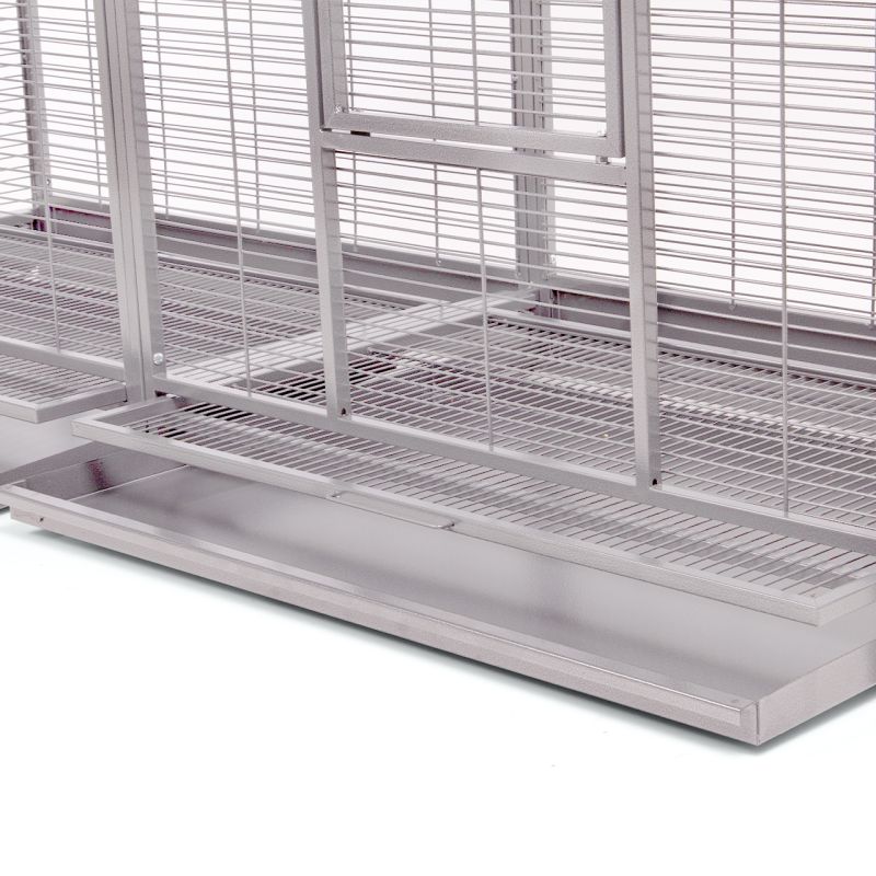 Détail de la structure métallique d'une volière avec grille, fond et bac de récupération.