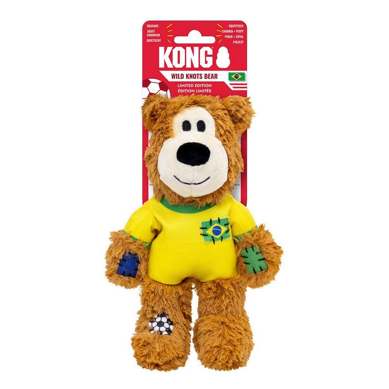 Orsacchiotto di peluche marrone con maglietta gialla e colletto verde. Sul petto una toppa con bandiera brasiliana. Altre toppe, tra cui un pallone da calcio, sugli arti. Muso bianco, occhi neri, bocca sorridente. Cartoncino rosso sul retro.