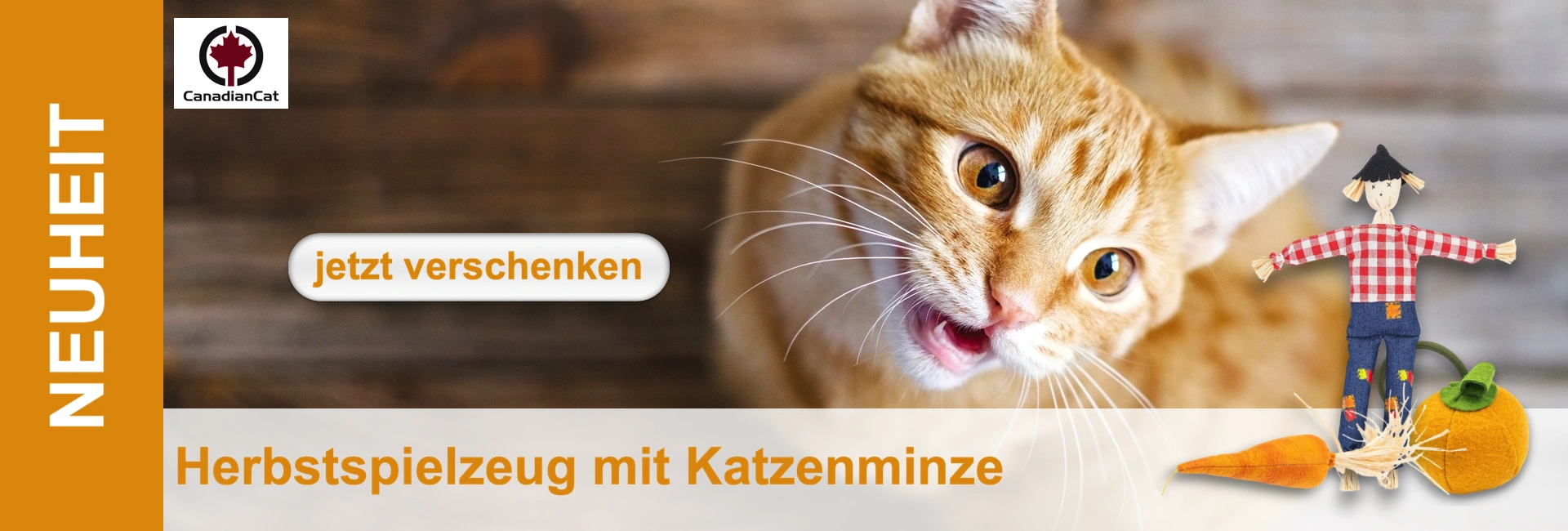 Primo piano di un gatto rosso con la bocca aperta, accanto a un giocattolo a forma di carota e a uno spaventapasseri.