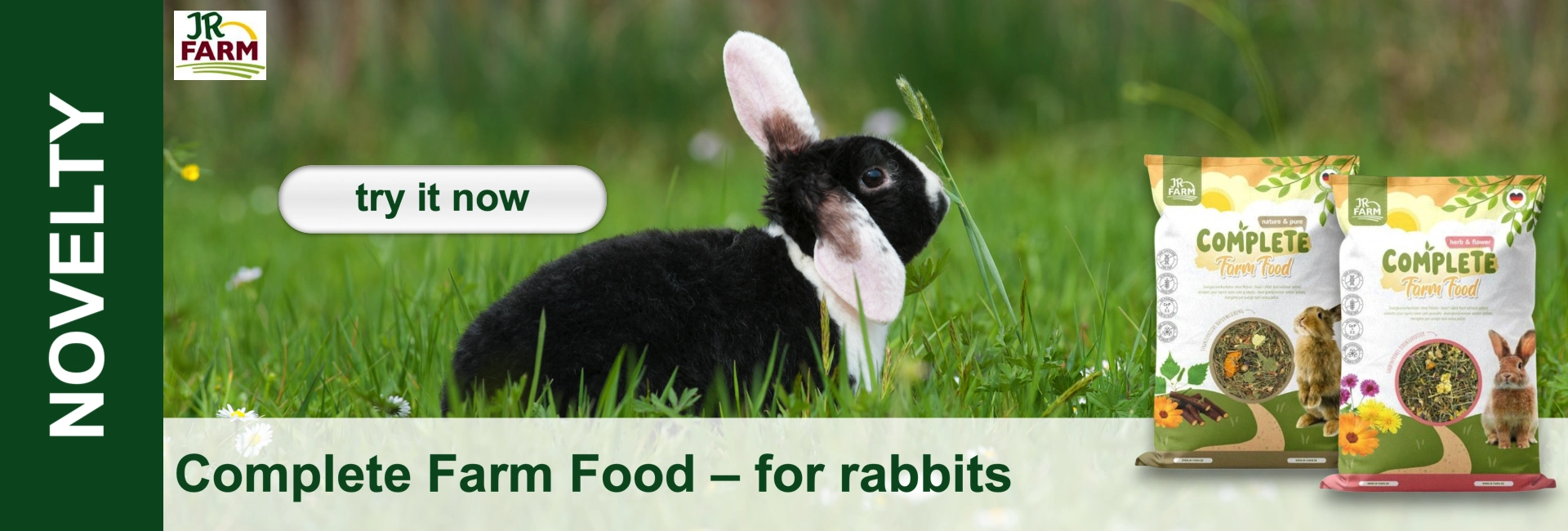Black-and-white rabbit with white floppy ears sits in a green meadow. Right: two packets of JR Farm Complete Farm Food for rabbits. Left: “NOVELTY” and a “try it now” button. Bottom: “Complete Farm Food – for rabbits”.
