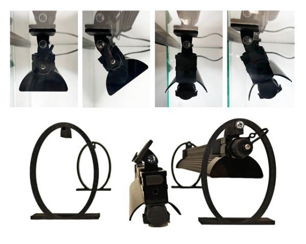 Das schwarze Arcadia LumenIZE Swing-Holder Set zeigt die flexible Neigung einer Terrarienbeleuchtung. Am Glasrand montiert, demonstriert es verschiedene Einstellwinkel zur gezielten Lichtausrichtung sowie eine freistehende Montageeinheit.