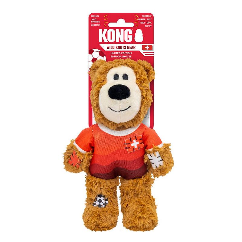 Morbido orsacchiotto di peluche marrone con maglia da calcio rosso-arancione con colletto e maniche bianchi. Sul petto: croce svizzera. Braccia e gambe con toppe in parte con motivo calcistico. Confezione rossa: «Kong Wild Knots Bear» e bandiera svizzera.