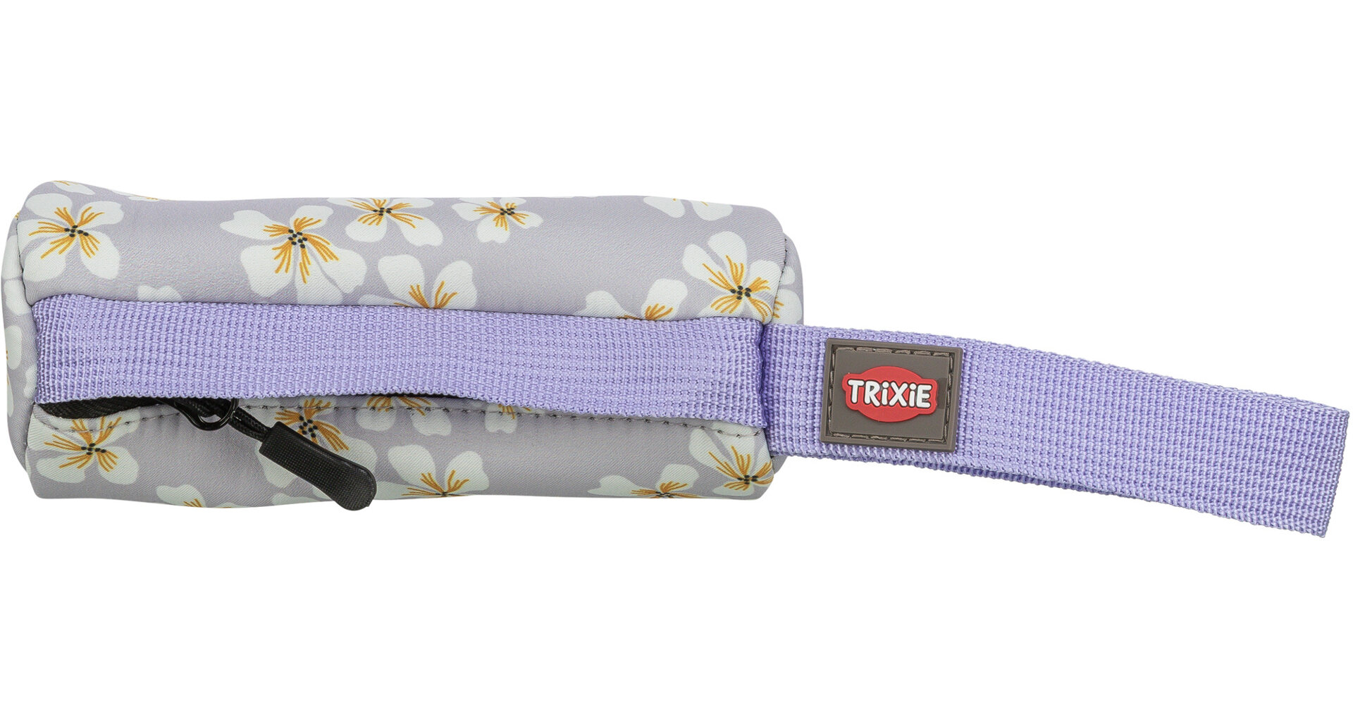 Ein lilafarbenes Täschchen mit weißen Blüten und gelber Mitte liegt horizontal. Unten ist ein schwarzer Reißverschluss, rechts ragt ein lilafarbenes Band mit braunem Etikett und rotem „TRIXIE“-Schriftzug heraus.