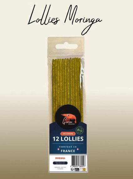 Bustina trasparente con 12 sottili lecca-lecca verdi alla moringa. Etichetta blu con logo Gloria Shrimp e diciture "ARTISANAL", "BIO", "12 LECCA-LECCA", "FABRIQUÉ EN FRANCE". La moringa favorisce la muta dei gamberetti.