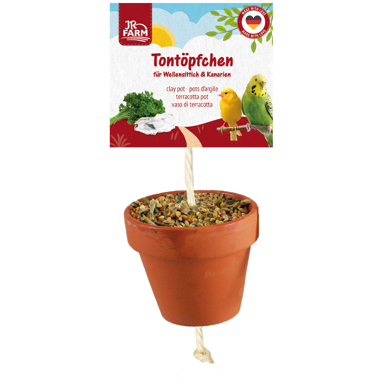 A brown clay pot containing birdseed, suspended from a string. Label: ‘Clay pots for budgies & canaries’, featuring parsley, a cuttlebone, a yellow canary and a green budgie. JR Farm logo.
