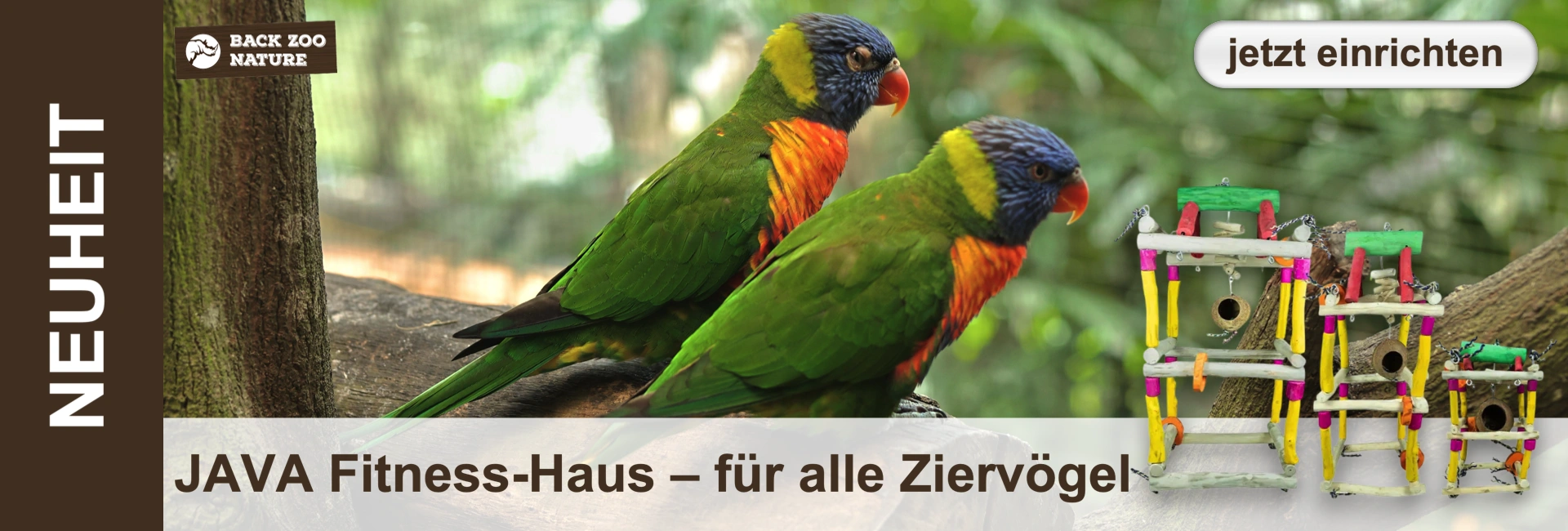 Zwei bunte Papageien mit grünem Gefieder, blauem Kopf, gelbem Nacken und oranger Brust sitzen auf einem dicken Ast. Im unscharfen grünen Hintergrund sind Blätter zu erkennen. Rechts drei farbenfrohe Vogelhäuser mit Kokosschalen.