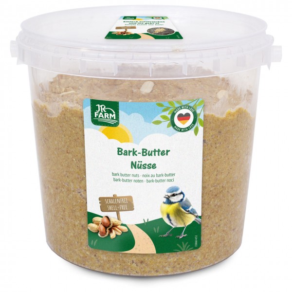 Transparente Wanne mit JR FARM Bark-Butter Nüsse, schalenfreies Vogelfutter auf Nussbasis. Etikett mit Blaumeise, Erdnüssen und Hinweis „Einfach aufzustreichen“. Ideal für Wildvögel als Streichfutter für Baumrinde.