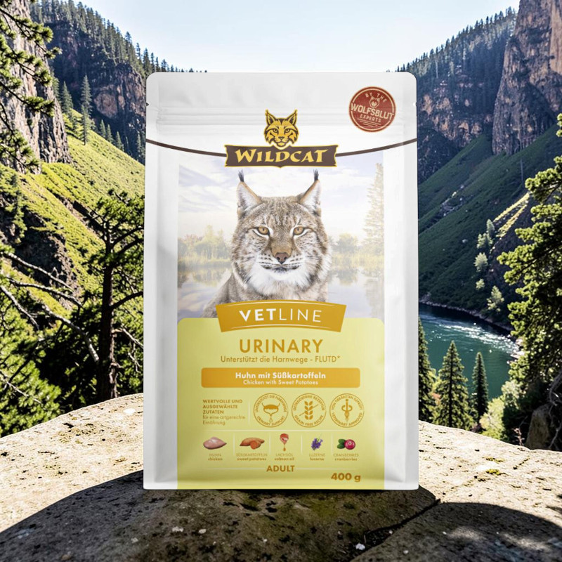 White Wildcat Vetline Urinary cat food pack featuring a lynx standing on a rock against a mountain backdrop with a river. Chicken flavour with sweet potatoes, supports urinary health, grain-free. Contents: 400 g.
