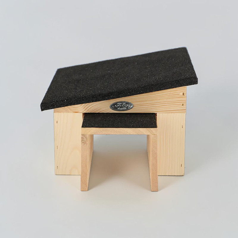 Abri pour hérissons Esschert en bois d'épicéa clair, doté d'un toit incliné en bitume foncé. Forme allongée et fermée avec un tunnel d'entrée. Offre aux hérissons un abri sûr pour se reposer, se cacher et hiberner. Plaque métallique à l'avant.