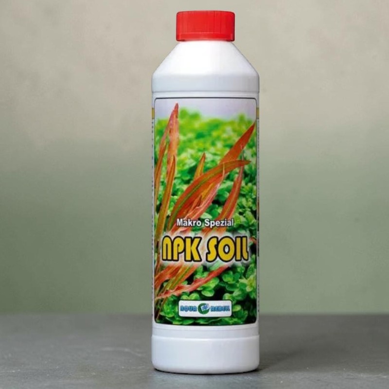 Weiße Flasche mit rotem Schraubverschluss. Etikett zeigt aquatische Pflanzen: vorn rötlich-braune, schmalblättrige, dahinter viele kleine hellgrüne Blätter. Aufdruck: "Makro Spezial NPK SOIL" und Aqua Rebell-Logo.