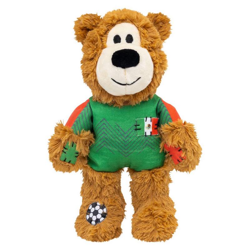 Morbido orsacchiotto marrone con maglia verde e maniche arancioni. Sul petto una piccola bandiera messicana. Discreto motivo a zig zag. Toppe con motivo calcistico sul piede sinistro, altre toppe in tessuto sulle braccia.