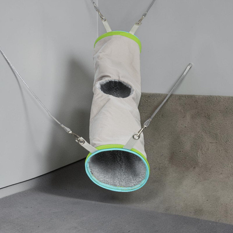 Hängender Kuscheltunnel aus hellbeigem Nylon, innen weich grau gepolstert. Offene Seite und runde Öffnung oben, beide mit hellgrünen und türkisen Rändern. Riemen mit Karabinern zur Käfigbefestigung, Spiel- und Schlafplatz.