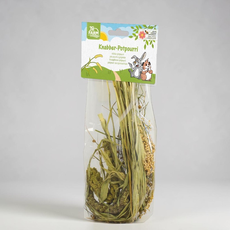 Transparente Plastiktüte mit JR FARM Knabber-Potpourri: Mischung aus getrockneten Gräsern, Hirsekölbchen und Körnchen für Kleintiere. Farbiger Etikettenkopf mit sonniger Landschaft, Kaninchen und Meerschweinchen.