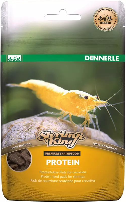 Verpackung von Dennerle Shrimp King Protein, ein gelbe Garnele sitzt auf einem Stein. Futter-Pads sind abgebildet.