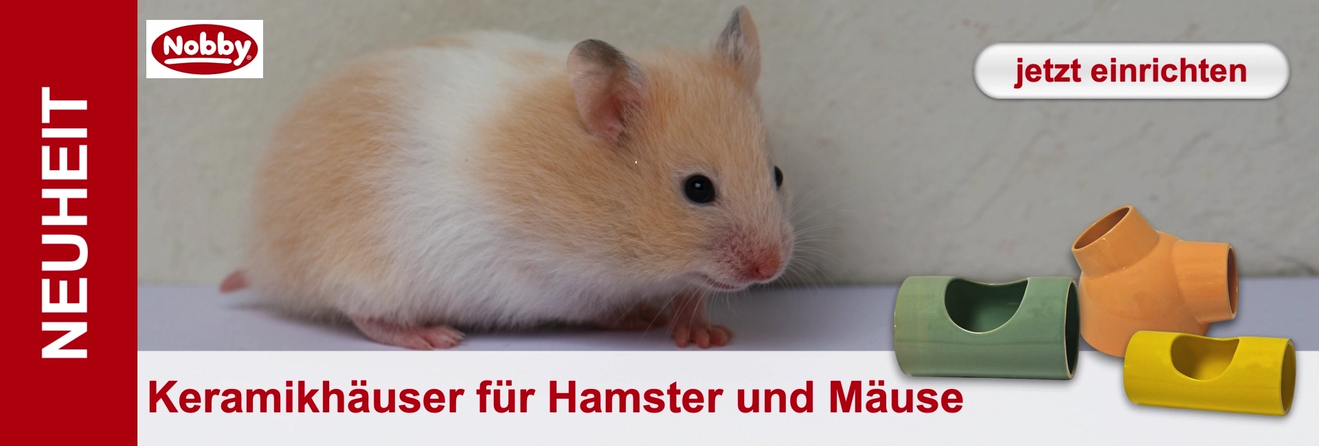 Kleiner plüschiger Hamster mit hellbraun-weißem Fell blickt nach rechts. Daneben drei farbenfrohe Keramikhäuser in Grün, Orange und Gelb als Unterschlupf oder Spielzeug. Bewirbt neue Nobby-Keramikhäuser für Hamster und Mäuse.