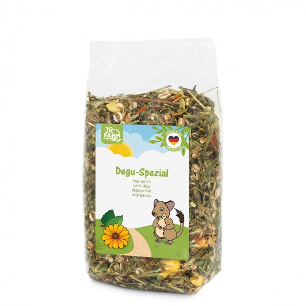 Transparente Verpackung mit JR FARM Degu-Spezialfutter, einer Mischung aus Kräutern, Getreide und Samen. Etikett mit Comic-Degu, gelber Blume, grünem Weg, sonnigem Himmel und dem Namen „Degu-Spezial“. Siegel mit deutscher Flagge.