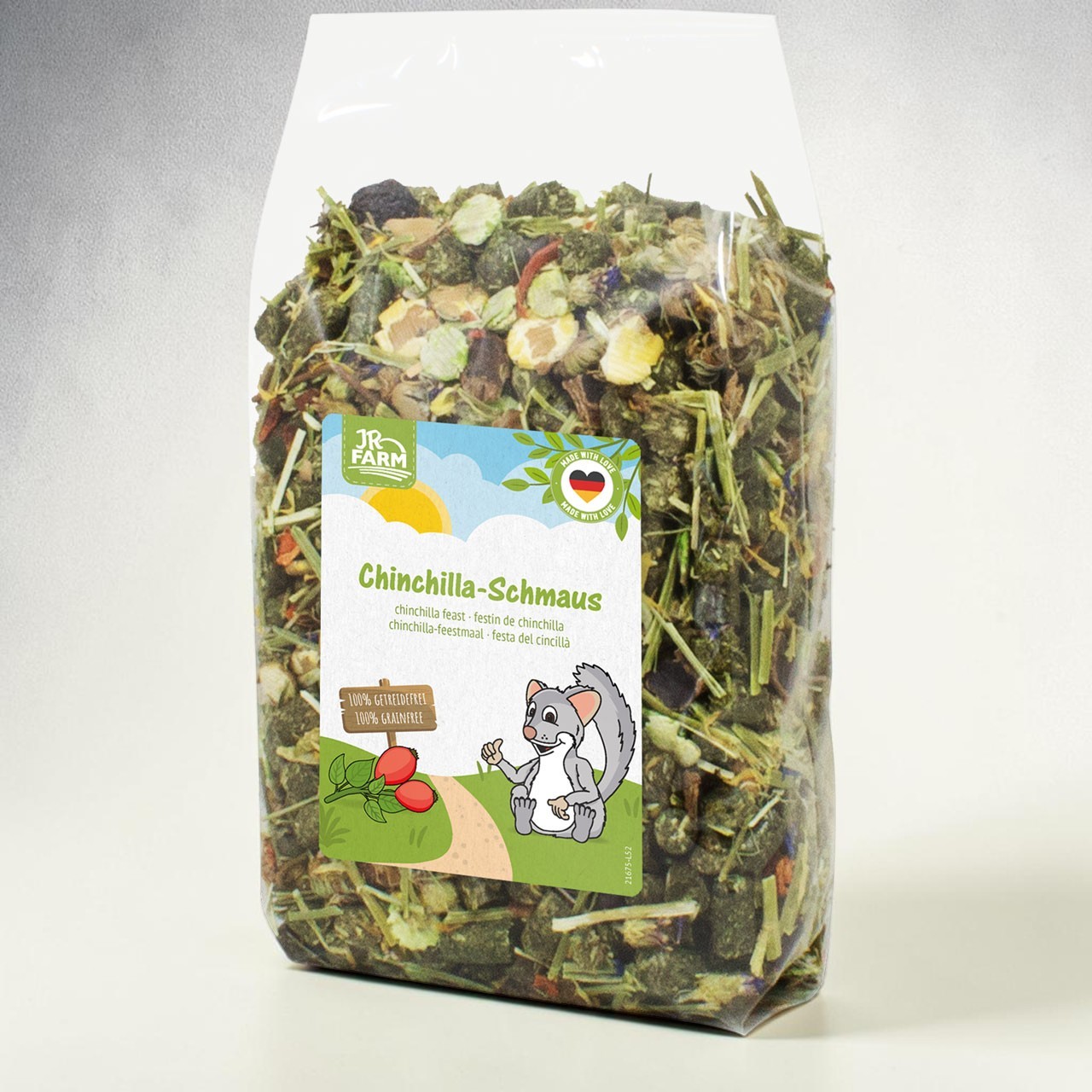 Transparent JR Farm ‘Chinchilla Feast’ packaging containing a mixture of dried herbs, leaves and pieces. Label: Cartoon chinchilla next to rose hips. Text ‘100% grain-free’ and ‘Made with Love’ seal.