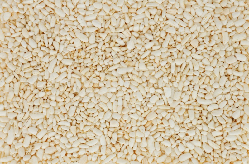 I chicchi di riso ovali di colore chiaro formano una superficie densa e strutturata. I chicchi sono di colore beige chiaro e di forma irregolare.