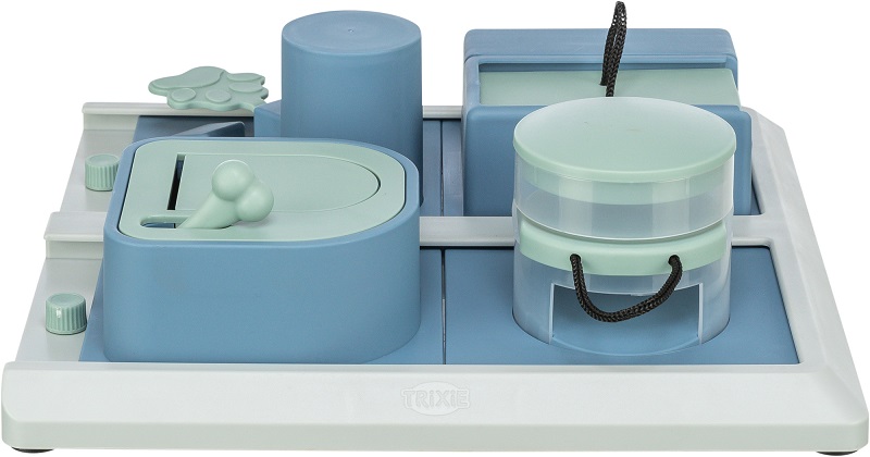 Jouet d'intelligence pour chiens bleu clair et vert menthe sur une base blanche. Avec des éléments interactifs : couvercle coulissant muni d'une poignée en forme d'os, bloc cylindrique, renfoncement et 2 récipients transparents munis de cordons à tirer.